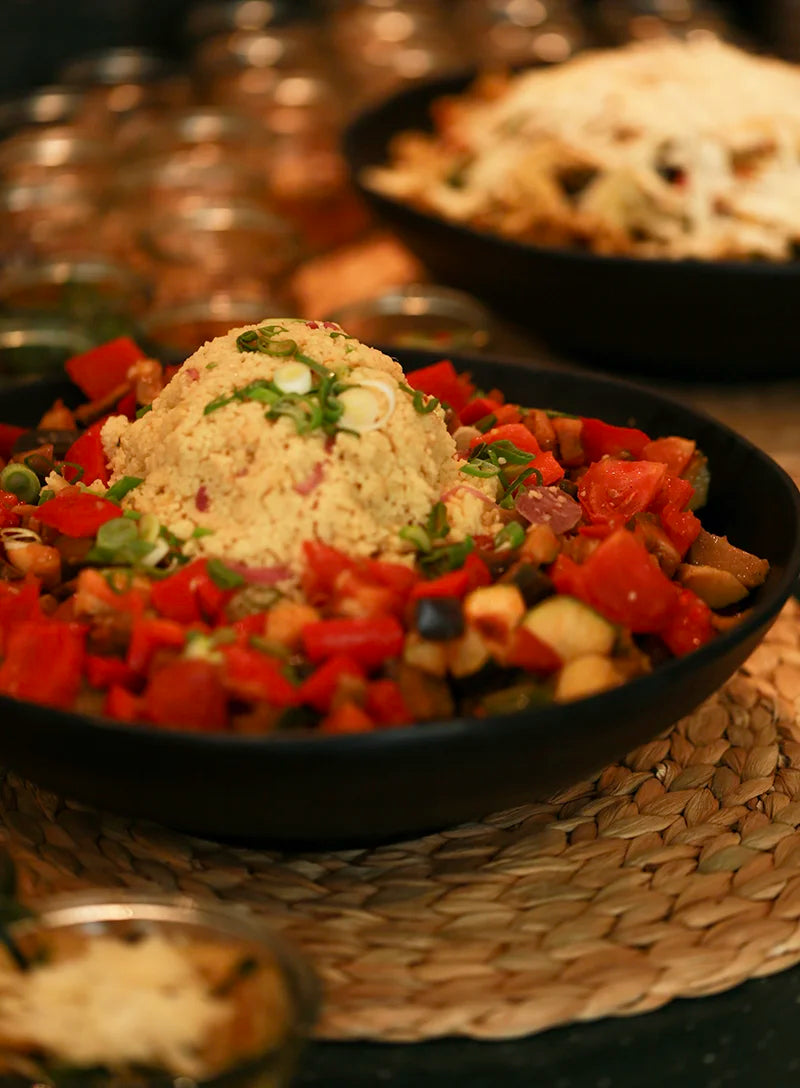 Vegetarisches Couscous-Gericht mit Paprika, Tomaten, Gemüse und frischen Kräutern.