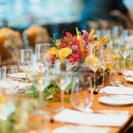 Festlich gedeckte Tafel mit Blumen und Gläsern für ein individuell geplantes Event Catering.